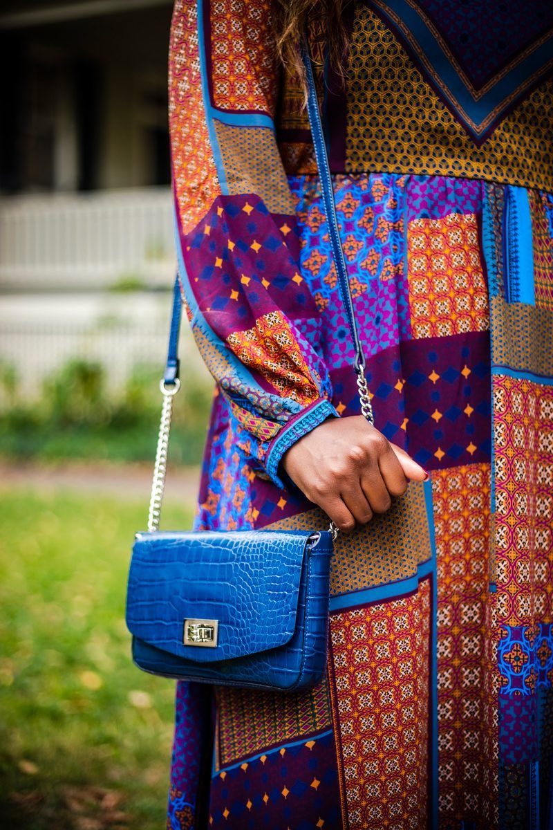 Scoop Faux Crocodile Small Crossbody Chain Strap Bag | Scoop at Walmart: A New Budget-Friendly Collection That Needs to Be On Your Radar by popular Washington DC fashion blogger, Alicia Tenise: image of a woman outside wearing a Walmart Scoop Scoop Blouson Sleeve Maxi Dress Chevron Print, Scoop Penny Microsuede High Heel Slouch Boot, and holding a Scoop Faux Crocodile Small Crossbody Chain Strap Bag.