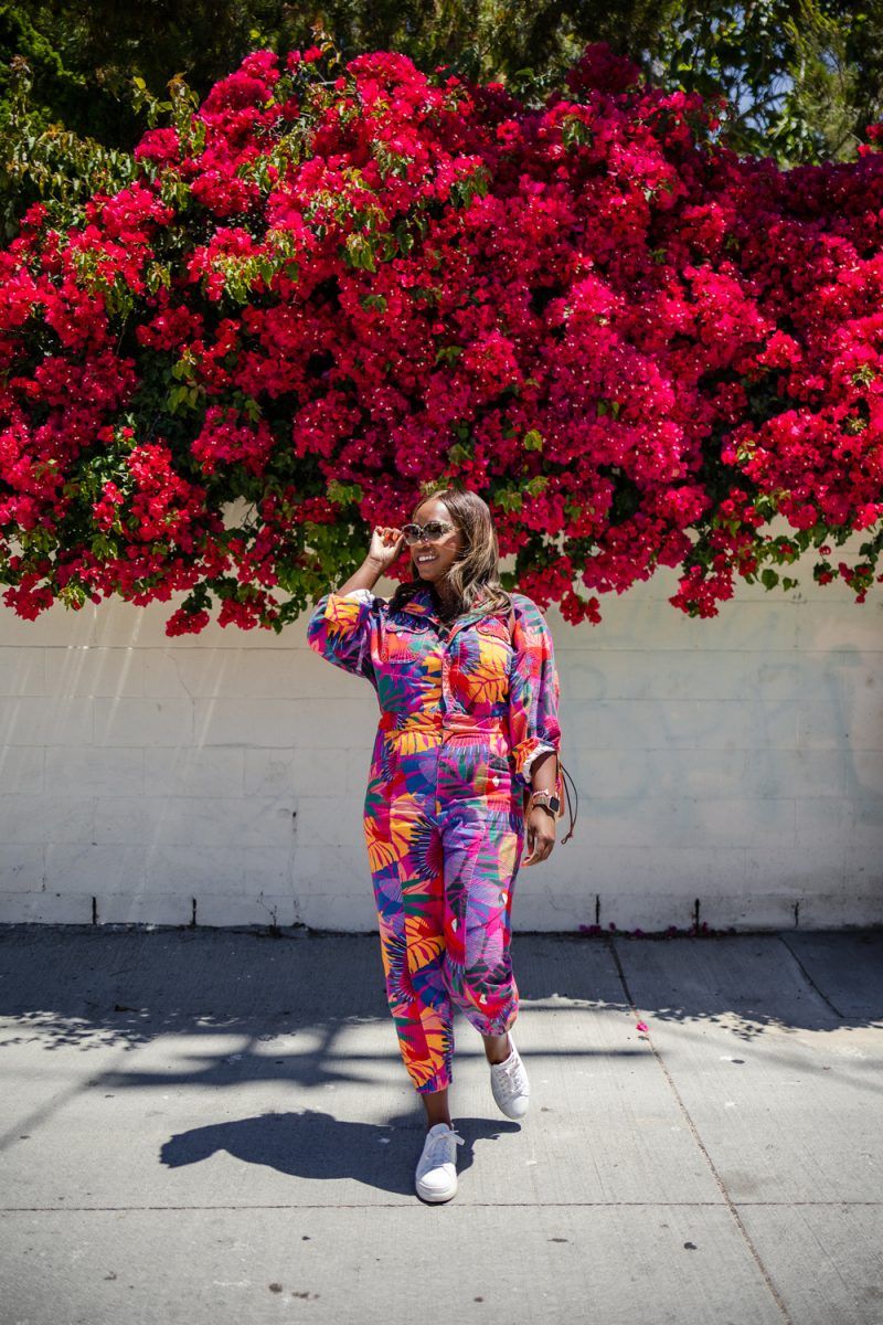 M.Gemi The Palestra Alta Platform Sneaker | Summer Jumpsuit by popular LA fashion blogger, Alicia Tenise: image of a woman wearing a summer jumpsuit with a pair of white sneakers and standing under a pink floral plant.