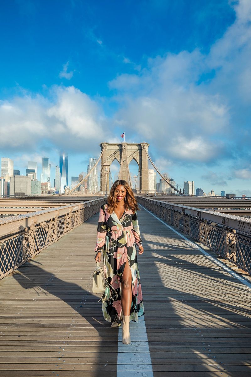 WONDROUS WATER LILIES BLACK FLORAL PRINT MAXI DRESS | Tom's Travel Photography Tips: How to Nail the Perfect Shot While Traveling by popular travel blogger, Alicia Tenise: image of a woman walking across the Brooklyn Bridge.