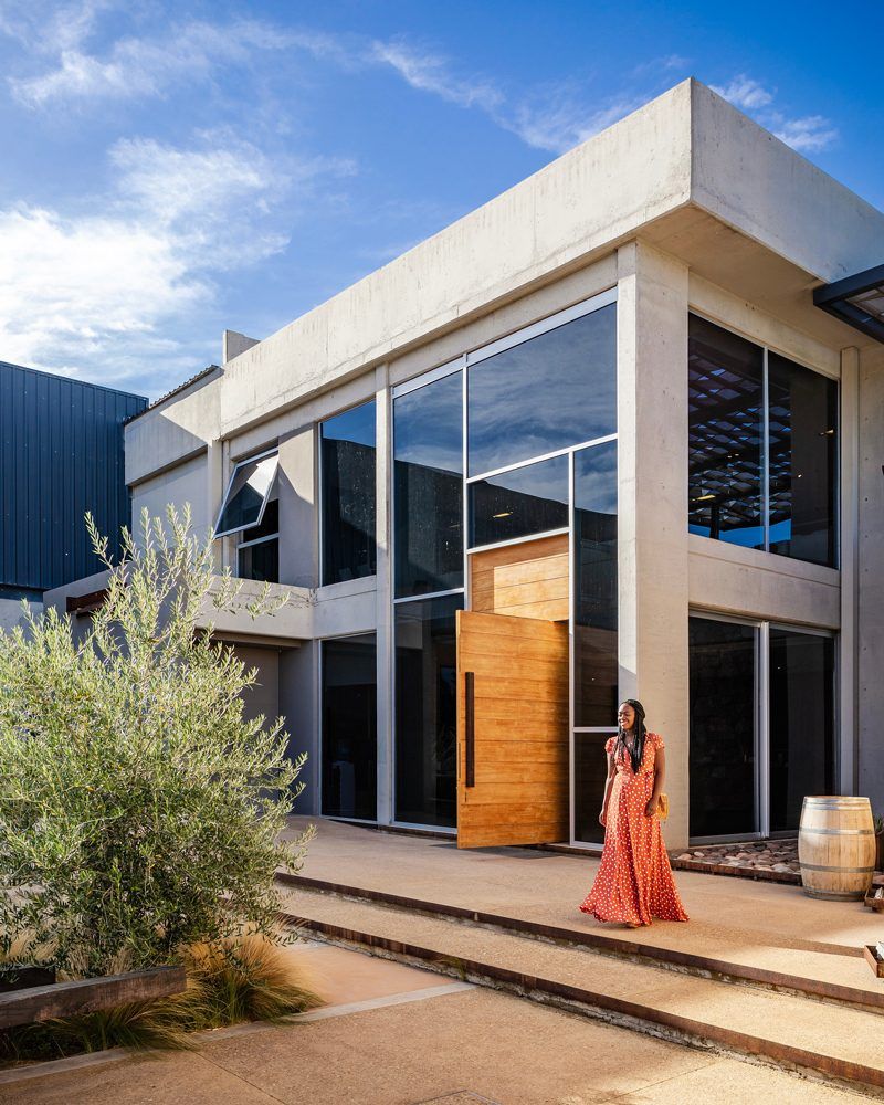 Tom's Travel Photography Tips: How to Nail the Perfect Shot While Traveling by popular travel blogger, Alicia Tenise: image of a woman standing outside of a industrial building.