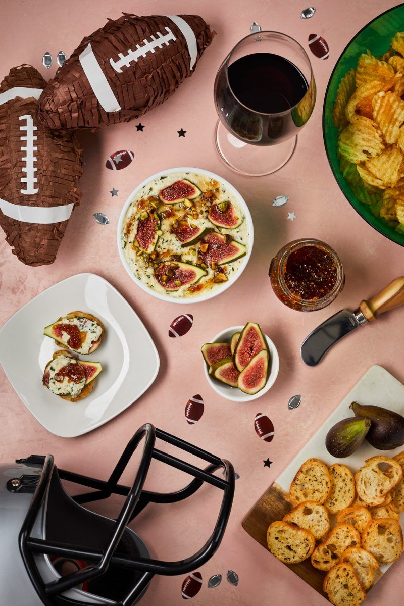 Football Party Ideas by popular D.C. lifestyle blogger, Alicia Tenise: image of chocolate covered strawberries, bowl of potato chips, glass of red wine, sliced figs, crostini bread slices, and bacon wrapped potato bites.