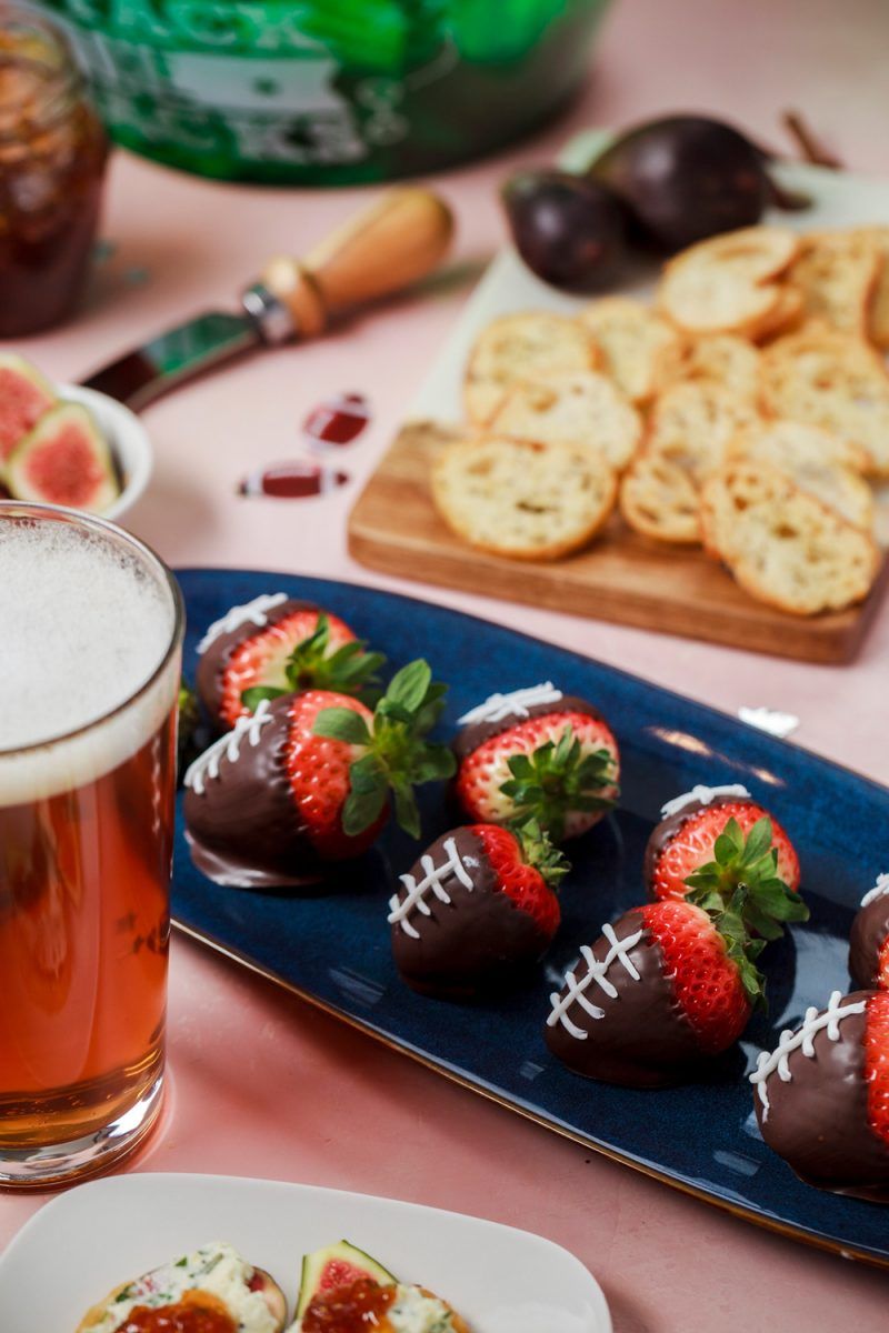 SUPER EASY FOOTBALL PARTY FOOD IDEAS 1/24/17 Tweet Pin 5.8K Share 32 5.8KSHARES Disclosure: This post contains some affiliate links, which means that if you click on one of the product links and make a purchase, I may receive a commission. This does not cost you anything additional, and helps me to keep the rest of my content free, so thank you! APPETIZERS AND SNACKS PERFECT FOR YOUR TAILGATE, HOMEGATE, OR BIG GAME PARTY 4 Super Easy Football Party Food Ideas Pause Unmute Remaining Time -2:55 With the Big Game coming up, I wanted to share some super easy football-themed snack ideas. These are all easy, and can be made at the last minute if you are suddenly inspired to up the game of your game day spread. And these aren’t just for a Big Game party… they are all easy enough to create for any game-watching get-together, tailgate, or even a sports-themed birthday party, so you will definitely want to pin these ideas for later! CHECK OUT FOUR SUPER EASY FOOTBALL PARTY FOOD IDEAS IN THIS YOUTUBE VIDEO: Speaking of, check out more football party inspiration on my Football Party board on Pinterest, and stay tuned to the blog later this week for a post on easy football decorations for your big game watch party. The thing that’s great about a football party is that it’s easy to incorporate creativity and DIY. Pretty much anything brown can become a little football with a little decoration. You’ll see a lot of that in this post. football party food ideas - football brownie bites Football brownies. You can make these the easy way with store-bought brownie bites, or if you have a little extra time, you can shape homemade brownies like footballs (see more on that below). Either way, brownies or brownie bites can become little footballs by adding a little white cake decorating icing. Just pipe on some little laces, and this snack is ready to go. easy football party food ideas - football brownies For homemade football brownies shaped like little footballs, make your favorite brownie recipe (like my popular Classic Brownies Recipe) or a boxed brownie mix for a shortcut. Use a circle cookie cutter with overlapping cuts to create little ovals. Pipe on laces with white cake decorating icing, and you’ve got a simple, but adorable dessert perfect for your football party. easy football party food ideas - chocolate covered strawberry footballs chocolate covered strawberry footballs - easy football party food idea Chocolate dipped strawberry footballs |Football Party Ideas by popular D.C. lifestyle blogger, Alicia Tenise: image of chocolate dipped strawberries.