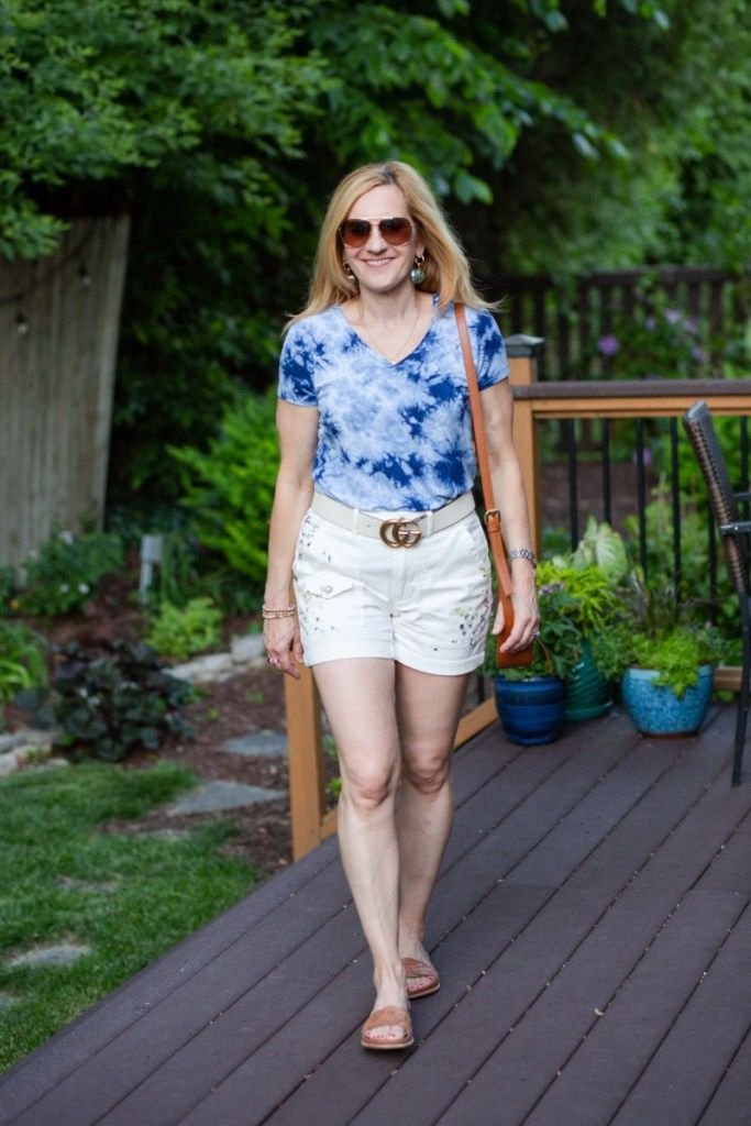Wearing white utility shorts with a blue tie dye tee and sandals.