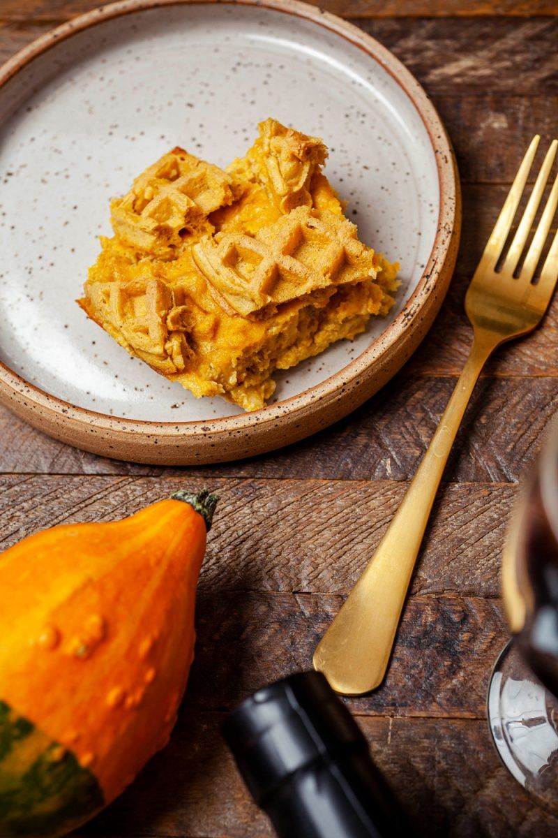 Pumpkin Waffle Bread Pudding | Trader Joe's Pumpkin Waffle Bread Pudding Recipe | Trader Joe's Fall Recipe Ideas | Trader Joe's Wine by popular D.C. lifestyle blogger, Alicia Tenise: image of pumpkin waffle bread pudding, mini pumpkins, cloth napkins, candle votive, and a bottle of red wine.