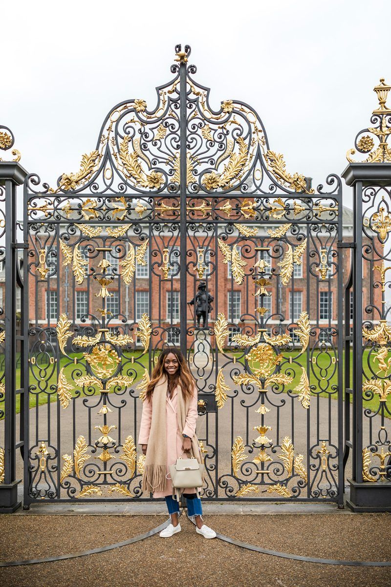 Virtual Tour Websites by popular D.C. travel blogger, Alicia Tenise: image of a woman standing in front of the gates of Buckingham Palace.