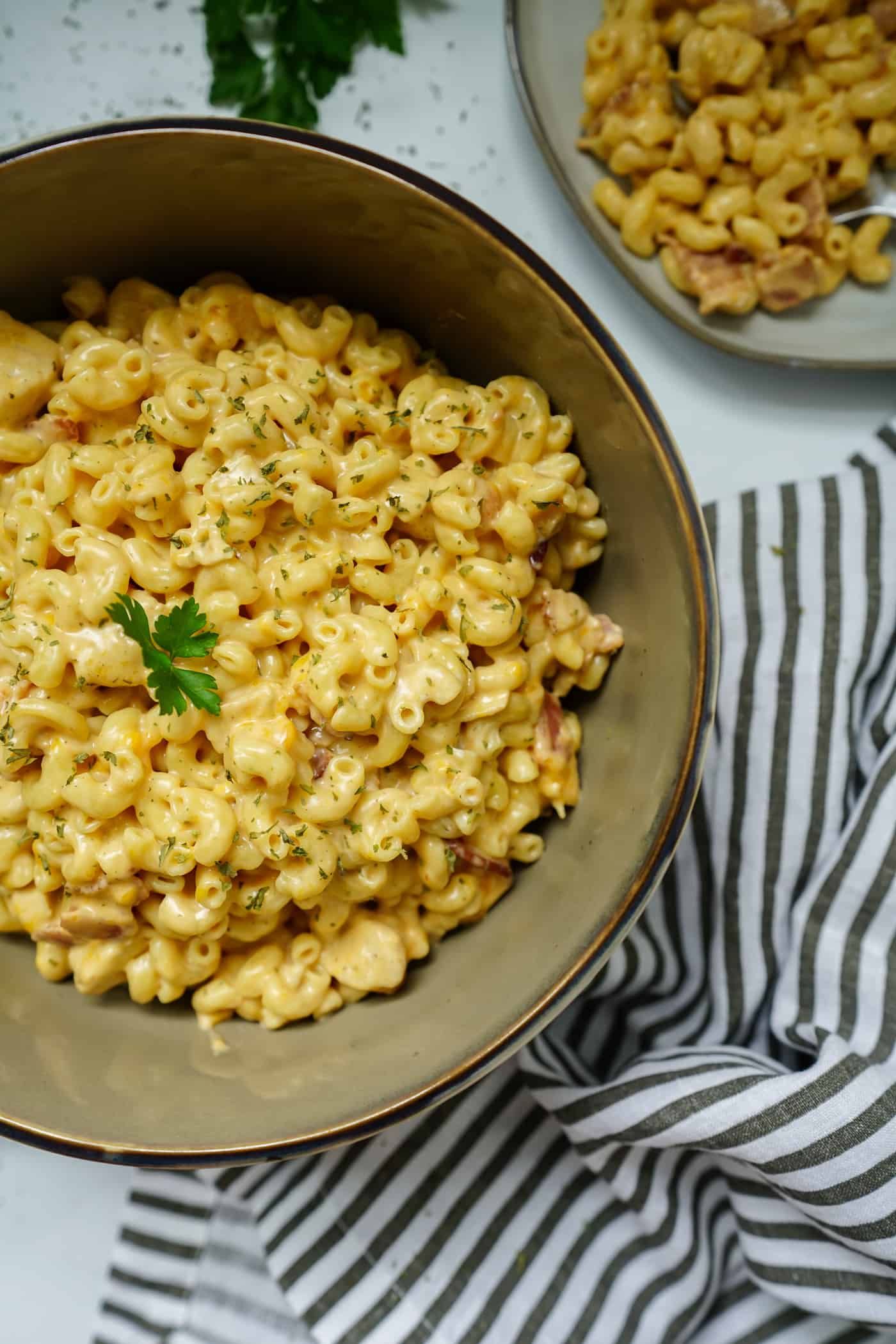 A large serving bowl of chicken bacon ranch pasta topped with fresh parsley