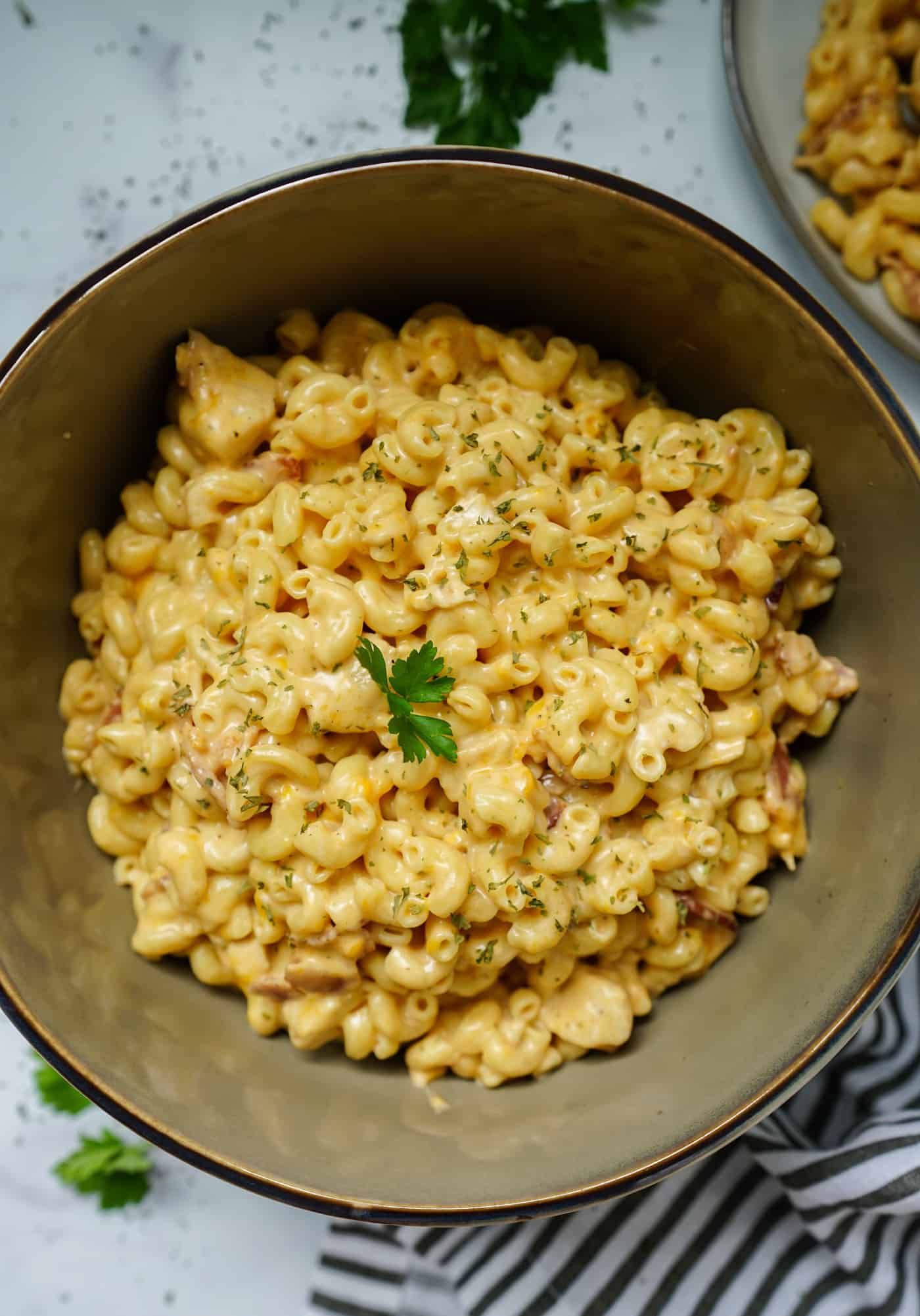 A large serving bowl of chicken bacon ranch pasta topped with fresh parsley