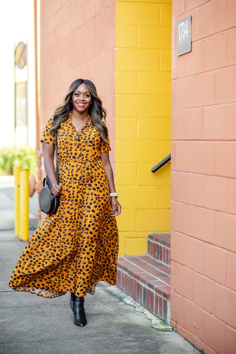 Anthropologie Vianne Maxi Shirtdress | Leopard Print Shirt Dress by popular D.C. fashion blogger, Alicia Tenise: image of Alicia Tenise walking outside next to a peach colored building and wearing a Anthropologie leopard print shirt dress, black point toe ankle boots and carrying a black circle purse.