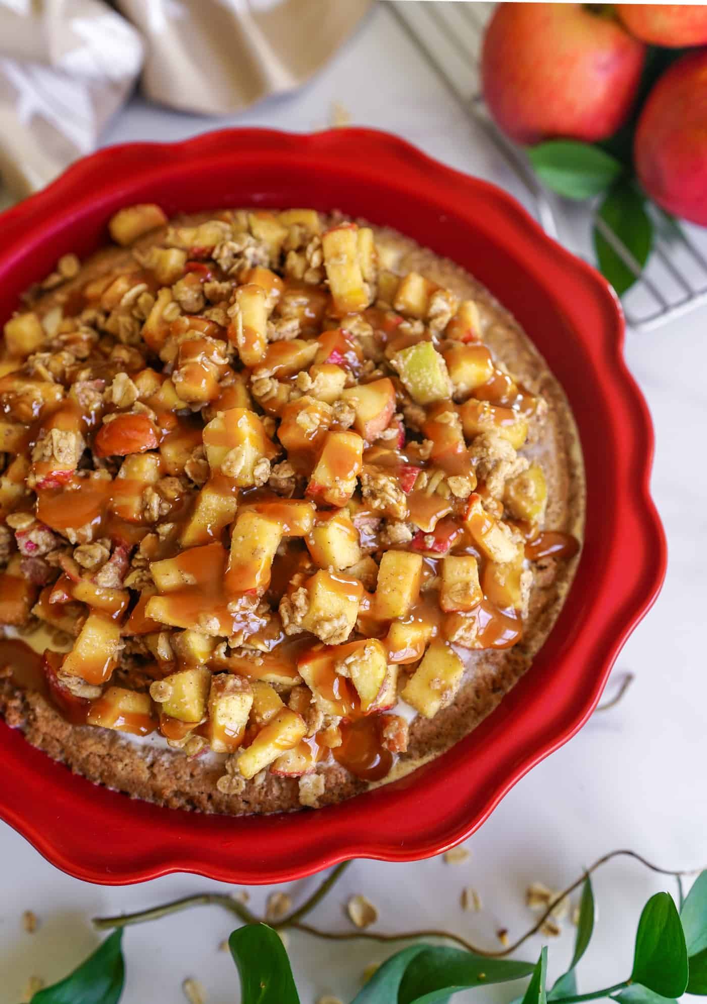 A 9 inch red pie pan filled with an apple crisp ice cream pie