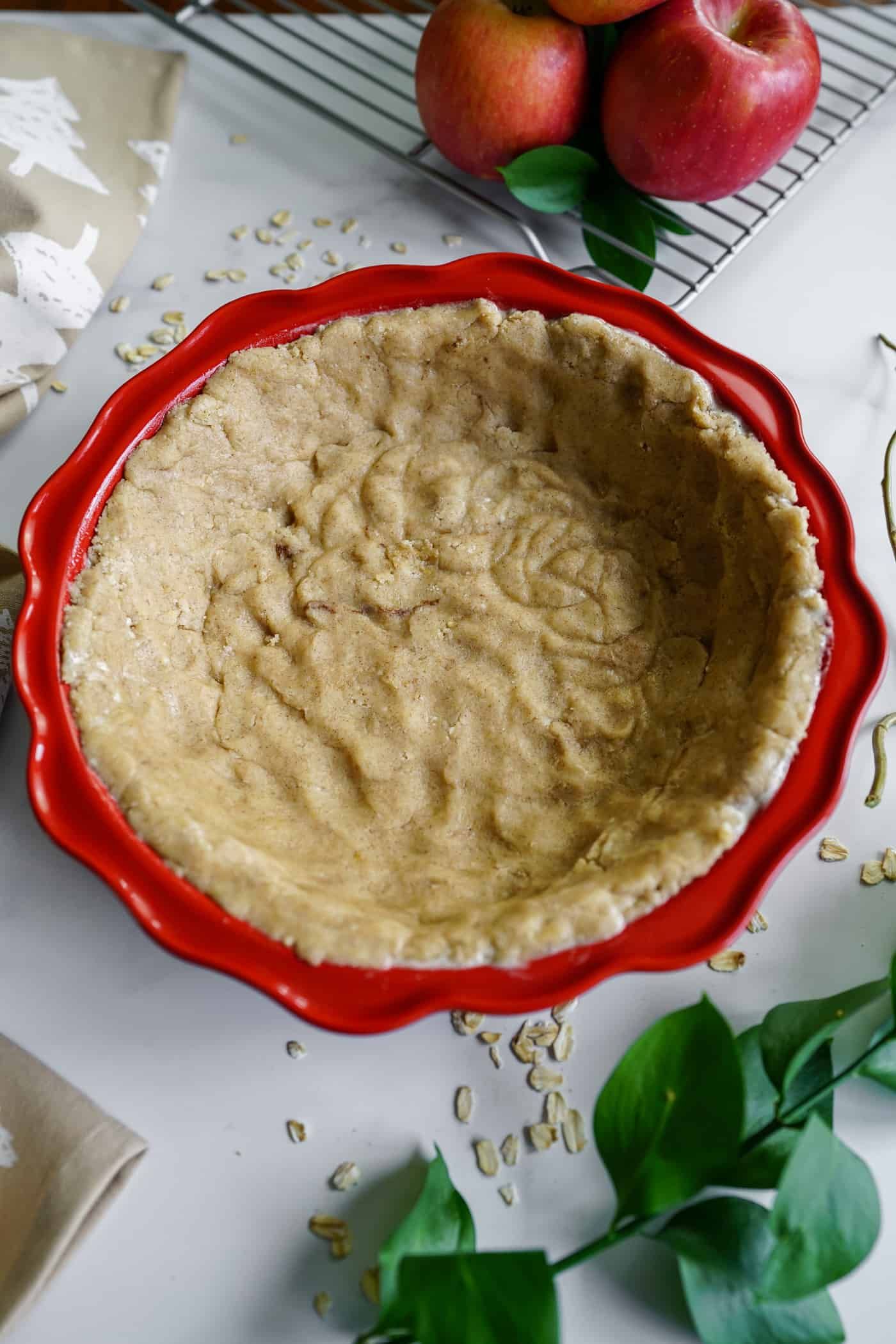 A red 9 ince pie pan filled with an emplty pie crust