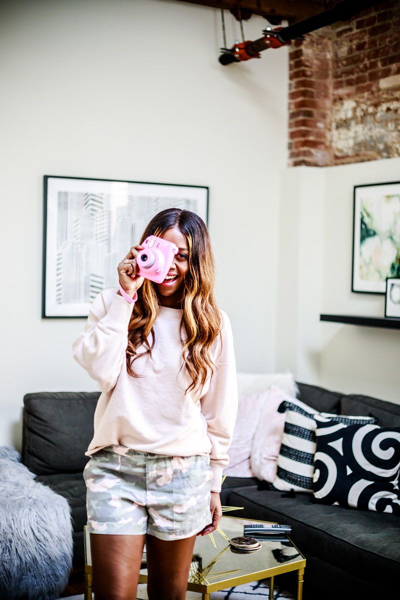 Instax Fuji in Pink - The Best Camera Gear Under $100 featured by popular Virginia blogger Alicia Tenise | Best Camera Gear by popular DC lifestyle blogger, Alicia Tenise: image of a woman holding a pink Instax Fuji camera.