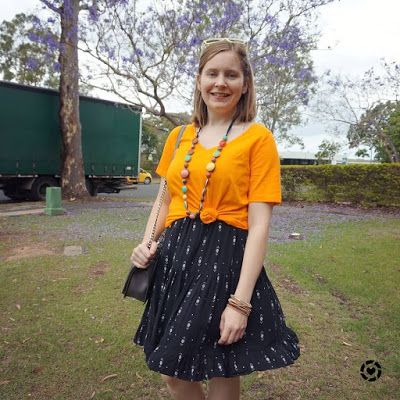 awayfromtheblue Instagram | marigold orange tee with black sundresses knotted spring layer bright necklace love bag